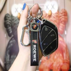 A hand holds a sleek black rongwei ei5 key cover with roewe branding, featuring a car icon design and a matching keychain, se...