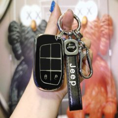 A hand holds a sleek black jeep key cover with a matching leather strap, designed for 2021 compass, cherokee, and grand chero...