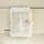 White, textured car tissue box with a flower design, hanging on a visor for convenient access.