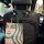 Elegant black flower-shaped car seat hooks with rhinestone accents, holding a starbucks bag for stylish in-car storage.