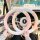 Plush winter steering wheel cover in soft pink and white, providing warmth and antifreeze protection for a cozy driving exper...