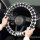 Black and white houndstooth-patterned rabbit fur steering wheel cover, providing warmth and a non-slip grip for comfortable d...