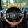 Leather diamond-patterned steering wheel cover in orange and brown, designed for summer anti-slip grip, showcased on a porsch...
