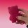 A hand holds a vibrant pink strawberry bear car key cover, featuring a silicone design with three buttons and a keychain loop...