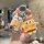 A hand holds a volkswagen car key cover featuring spongebob squarepants, paired with a matching spongebob charm, designed for...