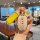 A hand holds a stylish key fob protector with a yellow strap and decorative egg charm, featuring the text everything will be ...
