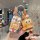 A hand holds a kia k3 key cover featuring a spongebob design with a cartoon character and a matching translucent keychain cha...