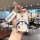 A hand holds a doraemon-themed xiaomi su7 nfc card key cover, featuring soft pu leather with a cute design and secure attachm...