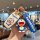 A hand holds a doraemon-themed key cover and matching keychain, featuring a cheerful blue robot design on a white case with a...