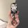 A hand holds a stylish wuling hongguang mini ev car key cover featuring a pastel macaron design with a cute cartoon cat adorn...