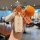 A hand holds a kia k5 car key cover with a silicone shell case, featuring a good luck tag and crocheted orange and garlic cha...