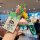 Hand holding a vibrant xpeng mona m03 car key cover featuring a cartoon design, paired with a matching keychain and lanyard f...