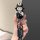 A hand holds a li l6 car key cover featuring a cute cartoon character in a black outfit, paired with a get rich keychain, des...