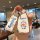 A hand holds a doraemon-themed key cover for the buick envision plus, featuring a soft rubber design with a cheerful cartoon ...