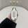 A hand holds a stylish wuling hongguang mini ev car key cover, featuring a macaron iii and game boy-inspired design with thre...