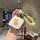 A hand holds a lynk & co 08 car key cover featuring a cute yellow duck design on a white background, encased in an aluminum s...