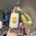 A hand holds a wuling xingguang car key cover featuring a cute yellow duck design with orange ears, attached to a bright yell...