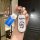 Hand holding a doraemon-themed car key cover for aito m7, featuring a blue and white design with the iconic character on a fu...