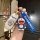 A hand holds a xiaomi su7 car key cover featuring a doraemon design, complete with a 3d doraemon charm and a matching blue st...