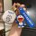 A hand holds a doraemon-themed key cover and accessories, featuring a blue doraemon charm and a matching keychain with the do...