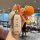 A hand holds a stylish gac aion y key cover with a design, accompanied by a crocheted orange and tag reading , set in ...