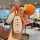 A hand holds a li auto l9 car key cover with a premium silicone shell, featuring a good luck tag and a knitted orange accesso...