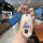 A hand holds a mercedes-benz e300l car key cover featuring a cute dachshund design with a blue leather strap, set against a m...