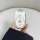 A hand holds a sleek white and silver key cover for the aima electric scooter, featuring lock, unlock, and play buttons, desi...
