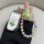 A hand holds a white kia k5 key cover adorned with a colorful flower design, paired with a vibrant beaded keychain featuring ...