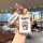 A hand holds a doraemon-themed car key cover and smart card case, featuring a cheerful doraemon design on a white background,...
