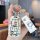 A hand holds a buick excelle car key cover featuring cartoon designs, including a smiling character and playful doodles, pair...