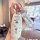 A hand holds a white gac aion y plus key cover featuring doraemon designs, including the character and doraemon text, with a ...