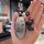 A hand holds a nissan tiana key cover featuring a cartoon dog with the text so , and a black deer charm with a blue eye...