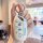 A hand holds a white roewe ei5 key cover featuring cute doraemon designs, including wow expressions and playful poses, set ag...