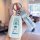 A hand holds a white toyota camry key cover featuring doraemon designs, including cute illustrations and the word doraemon, p...