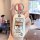 A hand holds a white roewe rx5 car key cover featuring a cartoon design with chinese text, offering full protection for the k...