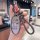 Hand holding a stylish nissan altima key cover featuring a cute cartoon design and braided strap, perfect for sentra 14th gen...