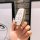 A hand holds a sleek ford escape key cover with gold trim and a white interior, featuring durable 3-button and 4-button desig...