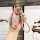 A hand holds a stylish wuling hongguang mini ev key cover, featuring a pink and silver design with a braided strap and decora...