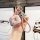 A hand holds a stylish pink wuling binguo plus key cover with a braided strap and a decorative snake-shaped charm, set agains...
