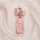 Elegant pink leather key cover for xiaopeng p7, featuring a bow and heart charm, displayed on soft fabric.