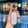 A hand holds a stylish aito m9 key cover with a mickey mouse-inspired design, featuring a white textured surface and gold acc...