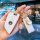 A hand holds a white leather bmw key fob cover with gold trim, featuring free engraving and decorative charms, designed for b...