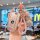 A hand holds a pink bmw key cover with a braided strap and decorative charm, featuring a (wealth) emblem, set against a mcd...