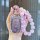 A hand holds a sparkling purple wuling hongguang mini ev key cover, adorned with beaded charms and a bow, designed for the 20...