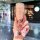 A hand holds a pink, glittery chery tiggo 8 pro key cover with a butterfly charm, set against a blurred shopping mall backgro...