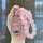 A hand holds a pink, glittery chery arrizo 5 plus key cover leather case adorned with clear beads and a bow, showcasing its e...