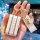 A hand holds a stylish tank 300 key cover featuring a white leather case with gold trim, a decorative clover charm, and a tag...