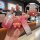 A hand holds a pink gradient changan key cover with a cute bear charm and wrist strap, showcasing its front view in a cozy ca...
