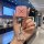 A hand holds a zeekr 001/007/009 key cover featuring a pink glittery design with a bluetooth-enabled car key fob, set against...
